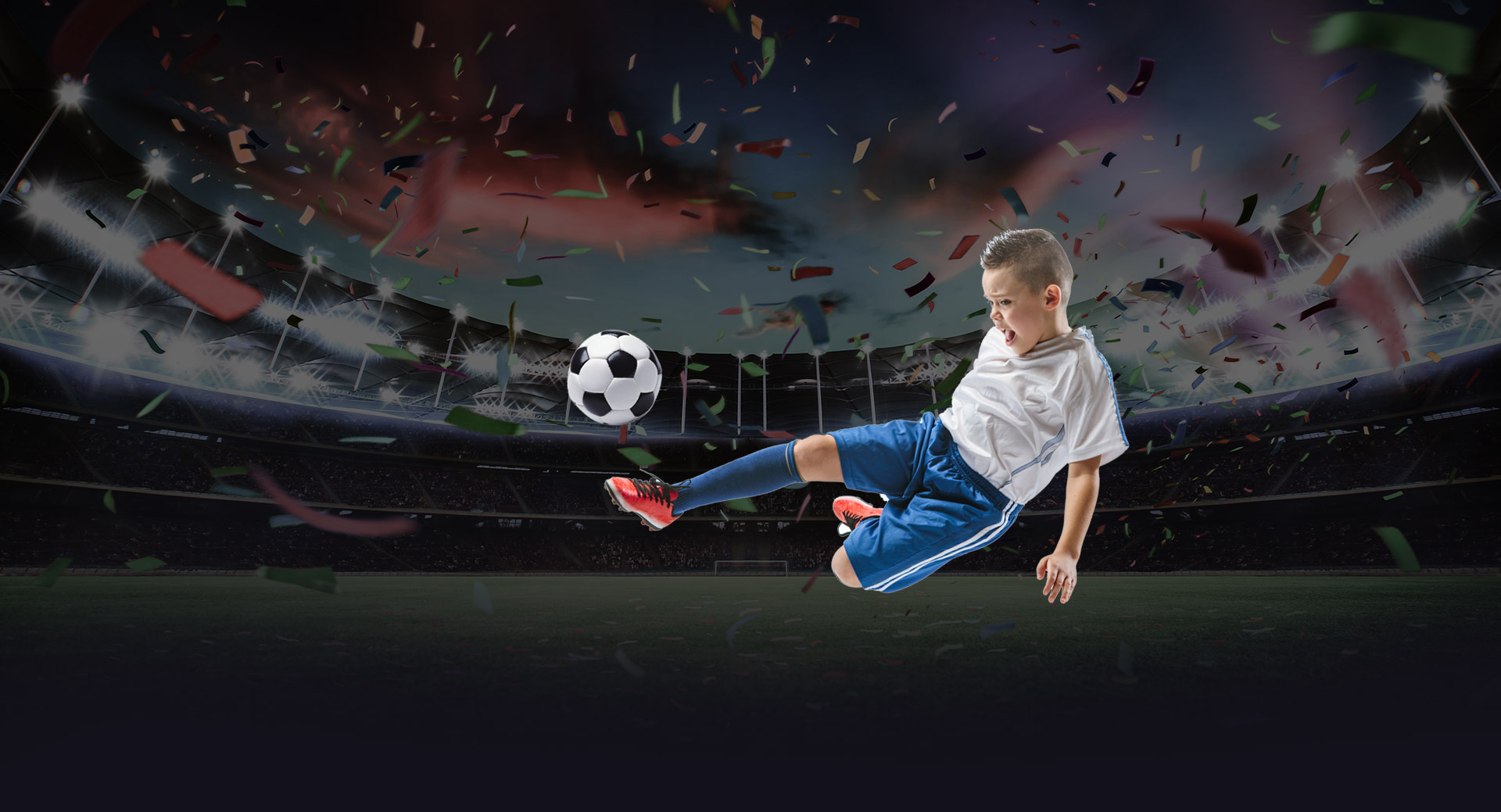 Dečak sa fudbalskom loptom na stadionu